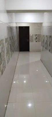 a hallway with a black door and a white tile floor at SAMPATH RESIDENCY in Palani