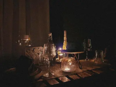 a table with wine glasses and a bottle on it at Bendheka - Cliff Front Cottages Coorg in Gonikoppal
