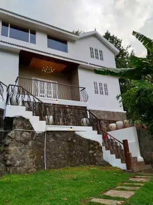 a white house with stairs in front of it at INN THE MOUNTAIN'S in Kodaikānāl