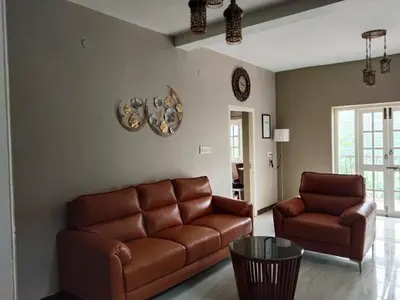 a living room with a couch and a table at INN THE MOUNTAIN'S in Kodaikānāl