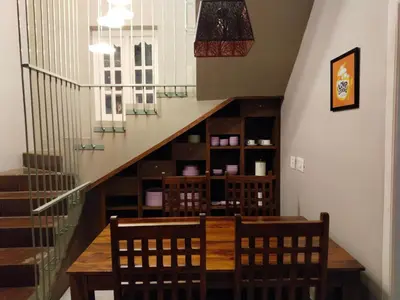 a dining room with a table and chairs and a staircase at INN THE MOUNTAIN'S in Kodaikānāl