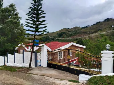 a house with a fence and a tree at INN THE MOUNTAIN'S in Kodaikānāl