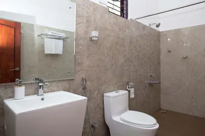 a bathroom with a white toilet and a sink at StayVista at Ivory Hill Madikeri including breakfast 3 Bhk Villa in Madikeri