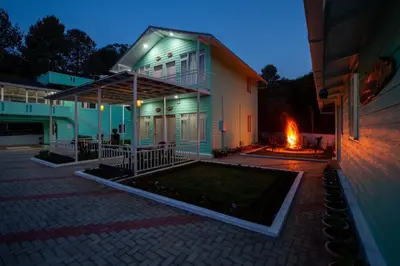 a house with a fire pit in front of it at Blossom Inn in Coonoor