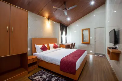 a hotel room with a bed and a tv at Blossom Inn in Coonoor